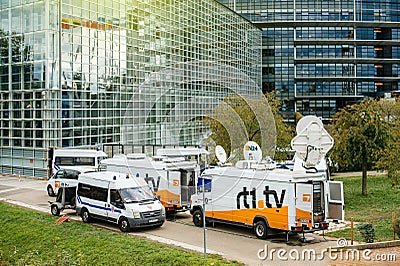 Multiple Media TV Trucks reporting live and police van surveilling the zone Editorial Stock Photo