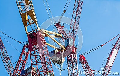 Multiple tower cranes above a concrete structure Stock Photo