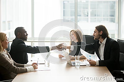 Multiracial businessmen in suits handshaking at executive team o Stock Photo