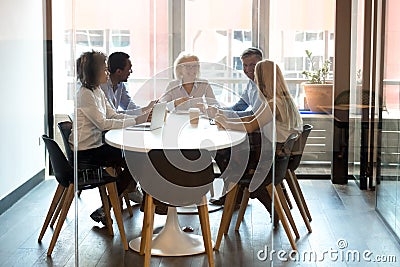 Multiracial company staff laughing talking at group meeting in office Stock Photo