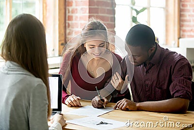 Multiracial couple signing deal from real estate agent Stock Photo