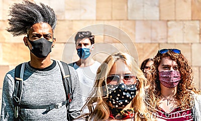 Multiracial crowd walking near wall at city urban context - New normal lifestyle concept with young people covered by mask Stock Photo