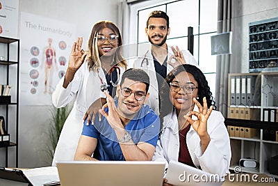 Multiracial doctors showing okay approval sign at office meeting Stock Photo