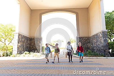 Multiracial elementary schoolboys with backpack entering school Stock Photo