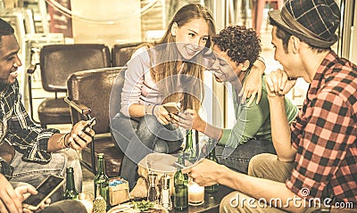 Multiracial friends drinking beer and having fun with mobile phone Stock Photo