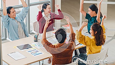 Multiracial group of young creative people in smart casual wear discussing business gesture hand high five, laughing and smiling Stock Photo