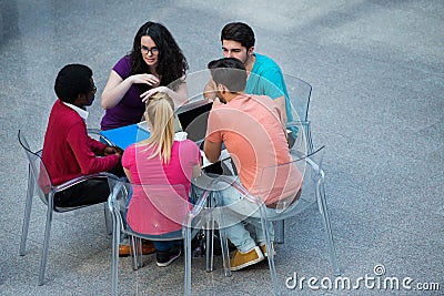 Multiracial group of young students studying together. High angle shot of young people sitting at the table. Stock Photo