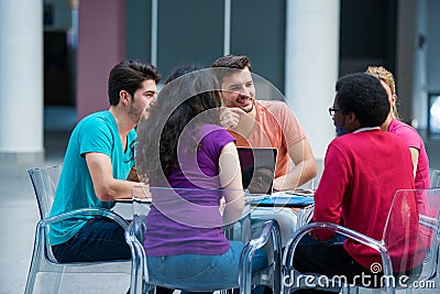 Multiracial group of young students studying together. High angle shot of young people sitting at the table. Stock Photo