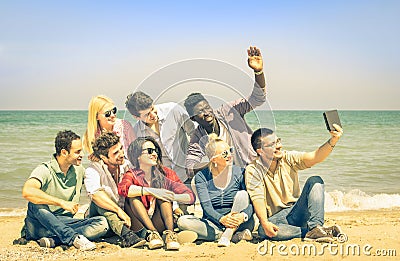 Multiracial happy friends taking selfie with tablet at beach Stock Photo