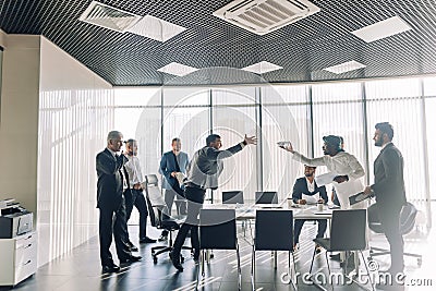 Multiracial partners dispute at negotiations, having fun while settling conflict Stock Photo