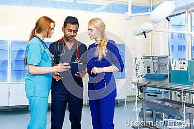 Multiracial team of doctors discussing a patient standing in a operating room Stock Photo