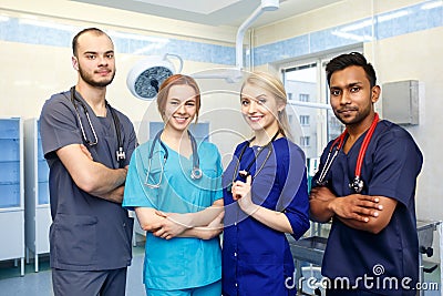 Multiracial team of young doctors in a hospital standing in a operating room Stock Photo
