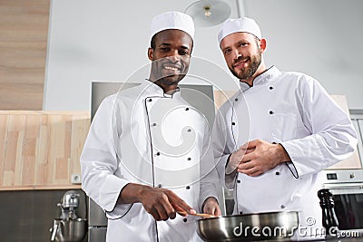 Multiracial team of male cooks working together Stock Photo