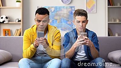 Multiracial teen boys chatting in social network instead of live communication Stock Photo