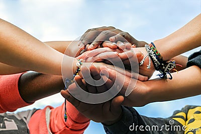 Multiracial teen friends joining hands together in cooperation Stock Photo