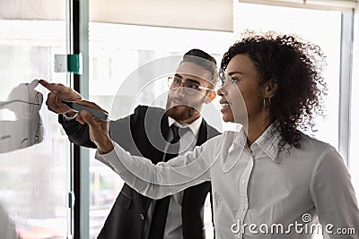 Multiethnic businesspeople develop business strategy on whiteboard Stock Photo