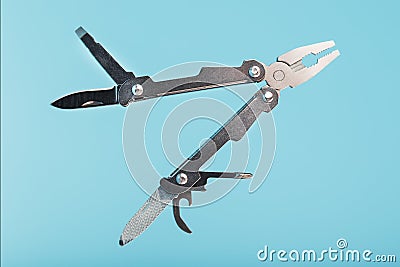 The multitool multi-function tool hovers on a blue background. The concept of an expanded multi-tool with free space Stock Photo