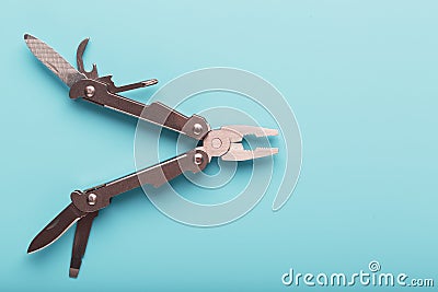 The multitool multi-function tool hovers on a blue background. The concept of an expanded multi-tool with free space Stock Photo