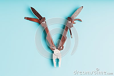 The multitool multi-function tool hovers on a blue background. The concept of an expanded multi-tool with free space Stock Photo