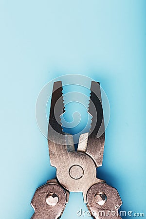 The multitool multi-function tool hovers on a blue background. The concept of an expanded multi-tool with free space Stock Photo