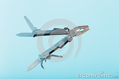 The multitool multi-function tool hovers on a blue background. The concept of an expanded multi-tool with free space Stock Photo