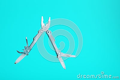 The multitool multi-function tool hovers on a blue background. The concept of an expanded multi-tool with free space Stock Photo