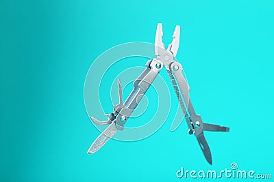 The multitool multi-function tool hovers on a blue background. The concept of an expanded multi-tool with free space Stock Photo