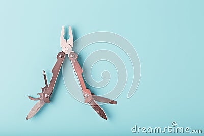 The multitool multi-function tool hovers on a blue background. The concept of an expanded multi-tool with free space Stock Photo