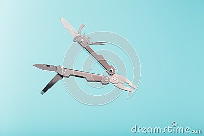 The multitool multi-function tool hovers on a blue background. The concept of an expanded multi-tool with free space Stock Photo