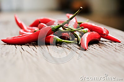 Multitude of red chili peppers on wooden table Stock Photo