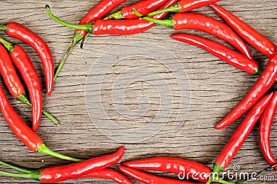 Multitude of red chili peppers on wooden table Stock Photo