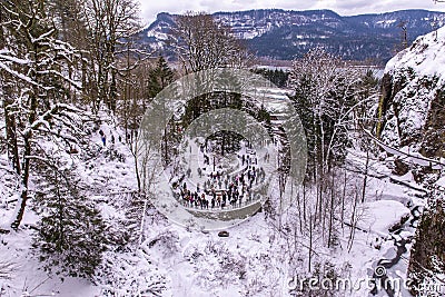 A crowd gathered at a viewpoint in front of Multnomah Falls on a cold winter day Editorial Stock Photo