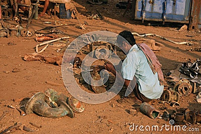 Mumbai/India - 23/11/14 - Ship breaker at work in Darukhana Ship Breaking yard, breaking apart mechanical equipment taken from the Editorial Stock Photo