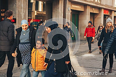 Munich, Germany, December 29, 2016: A friendly family of migrants walks down the street in Munich. Tolerance Editorial Stock Photo