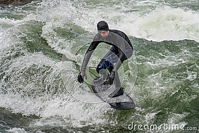Munich, Germany - October 13, 2023: Surfer in the city river called Eisbach at Munich, Germany Editorial Stock Photo