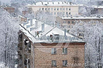 Municipal service workers removing snow off the roof Editorial Stock Photo