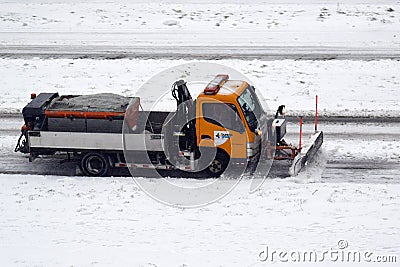 Municipal snowplow at work on snowy streets and roads Editorial Stock Photo