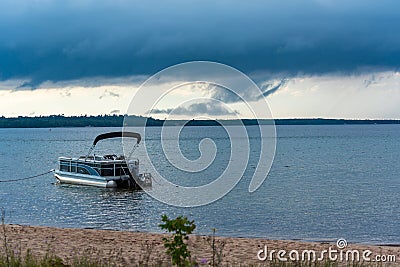 Munising Michigan, USA - August 11, 2021: Pontoon boat anchored near a beach Editorial Stock Photo