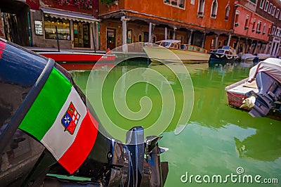 MURANO, ITALY - JUNE 16, 2015: Italy flag and shield on a boat engine above a green water in Murano canals Editorial Stock Photo