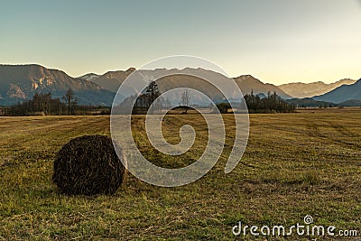 The Murnauer Moos on sunset with a hay bale in the foreground Stock Photo