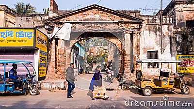 People walking past the ruins of an ancient arched brick gateway in the old town Editorial Stock Photo