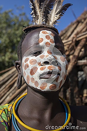 Girl from the Suri tribe poses for a photo with a traditionally painted face. Ethiopia Editorial Stock Photo