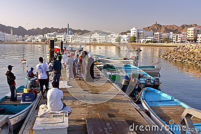 MUSCAT, OMAN - FEBRUARY 11, 2012: Fisherman at The Muttrah Fish docks early morning with Muttrah corniche in the Background Editorial Stock Photo