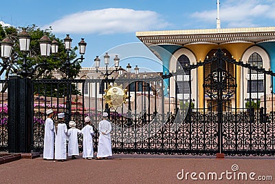 Small muslim boys in traditional kanduras standing in front of colorful Al-Alam Palace in Old Muscat, Oman Editorial Stock Photo