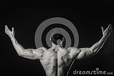 Muscular athlete demonstrates his muscles under load on a dark background Stock Photo