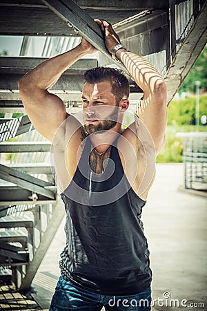 Muscular attractive athletic man in city under stairs Stock Photo