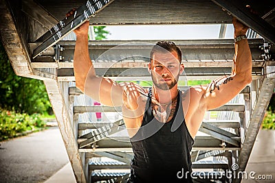 Muscular attractive athletic man in city under stairs Stock Photo