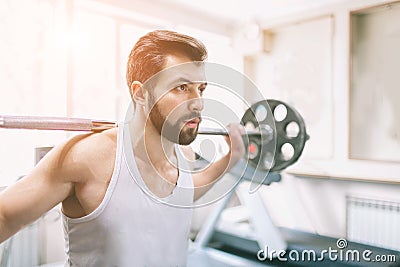 Muscular bearded man during workout in the gym. Bodybuilder doing weight lifting . Close up of young athletic female Stock Photo