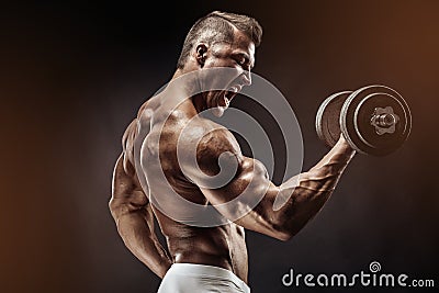 Muscular bodybuilder guy doing exercises with dumbbell Stock Photo