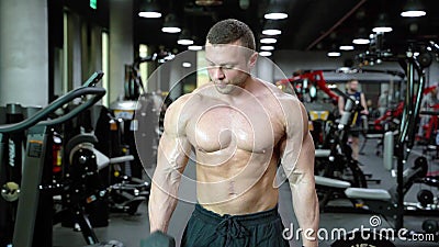 Muscular Bodybuilder Handsome Man with a Naked Torso Doing Exercises in